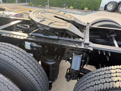 Volvo truck chassis shows fifth wheel mount and coupling components with dual rear wheels and suspension undercarriage.