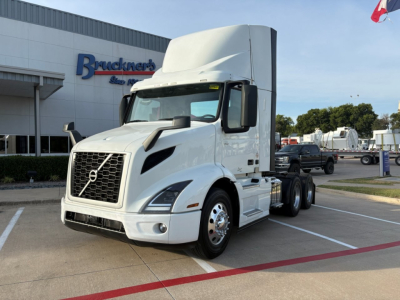 Volvo VNR64T300 daycab truck side view in a dealership lot with white cab and high sleeper