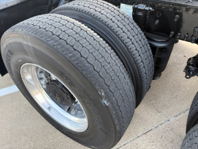 Volvo VNR64T300 truck wheel/tire assembly showing dual rear axle with large tread and rim, chassis components visible.