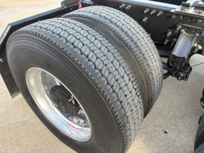 Dual rear truck tires and axle assembly of a 2022 Volvo VNR64T300 daycab showing dual tires and wheel hub with surrounding chassis components.