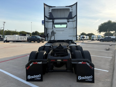 Truck chassis and rear view of a 2022 Volvo VNR64T300 tractor in a dealership lot, rear wheels visible, high cab back.
