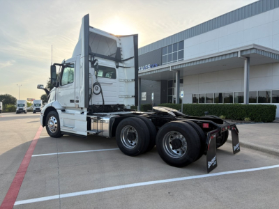 Volvo VNR64T300 truck chassis and cab in a dealership lot showing rear wheels and sleeper area.