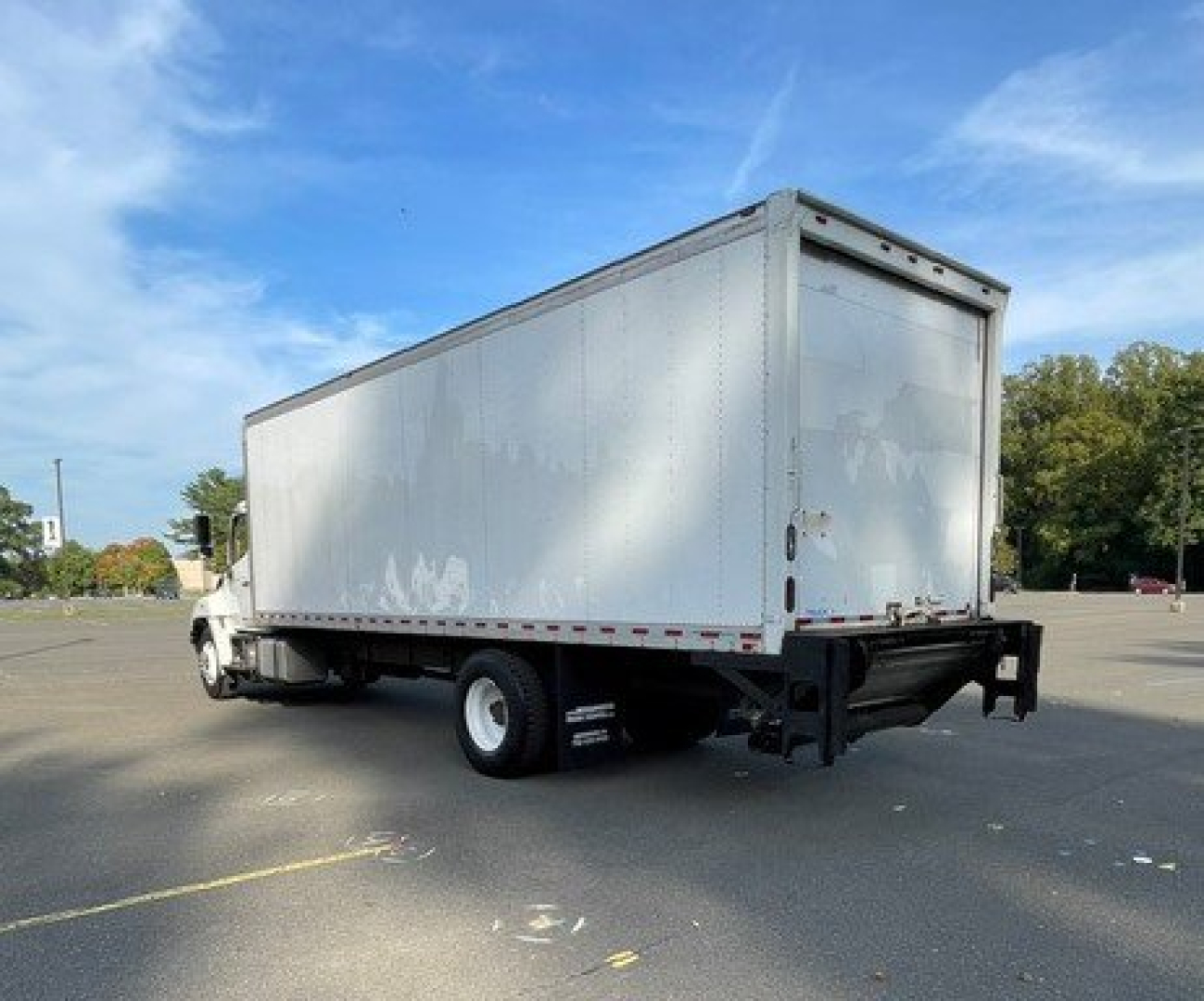 Box truck showing rear and side view of 2017 Hino 268 with a large silver cargo box and white cab, used vehicle.