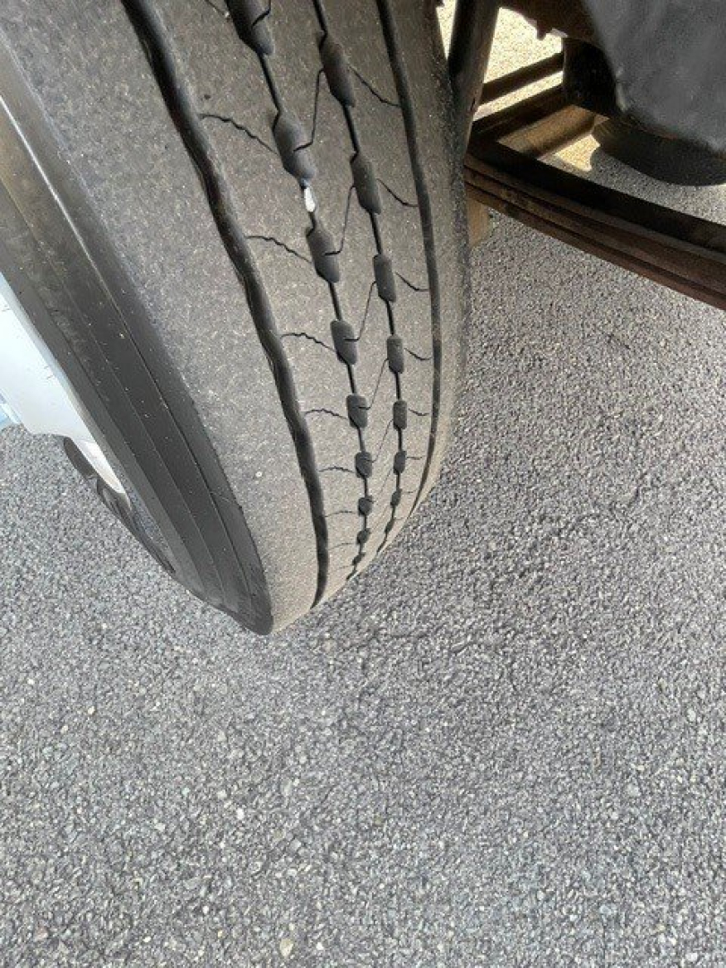 Tire tread and part of a Hino 268 truck suspension visible.