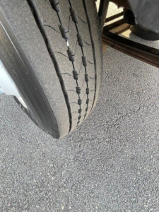 Tire tread and part of a Hino 268 truck suspension visible.