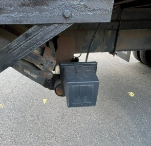 Underbody view of a 2017 Hino 268 showing a rectangular black auxiliary battery box mounted under the chassis near the frame and driveline components.