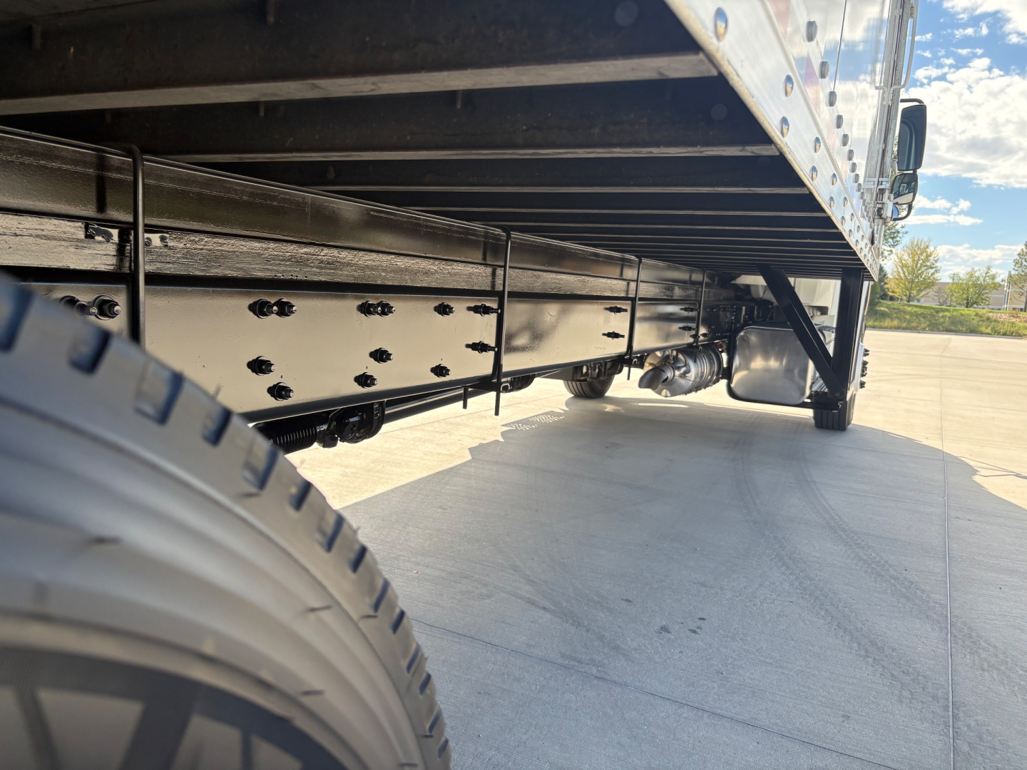 Freightliner M2-106 side view undercarriage showing frame rails and suspension with tire visible.