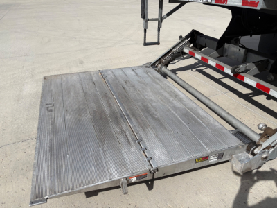 Aluminum loading ramp/platform extended from a Freightliner M2-106 truck showing surface ridges and hinge area.