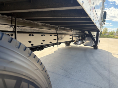 Freightliner M2-106 side view undercarriage showing frame rails and suspension with tire visible.