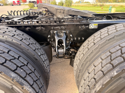 Kenworth T680 chassis undercarriage showing dual rear axles with heavy-duty suspension and mounting hardware