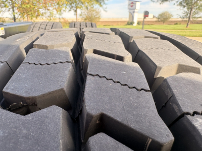 Tire tread close-up showing heavy duty truck tires on Kenworth T680 undercarriage.