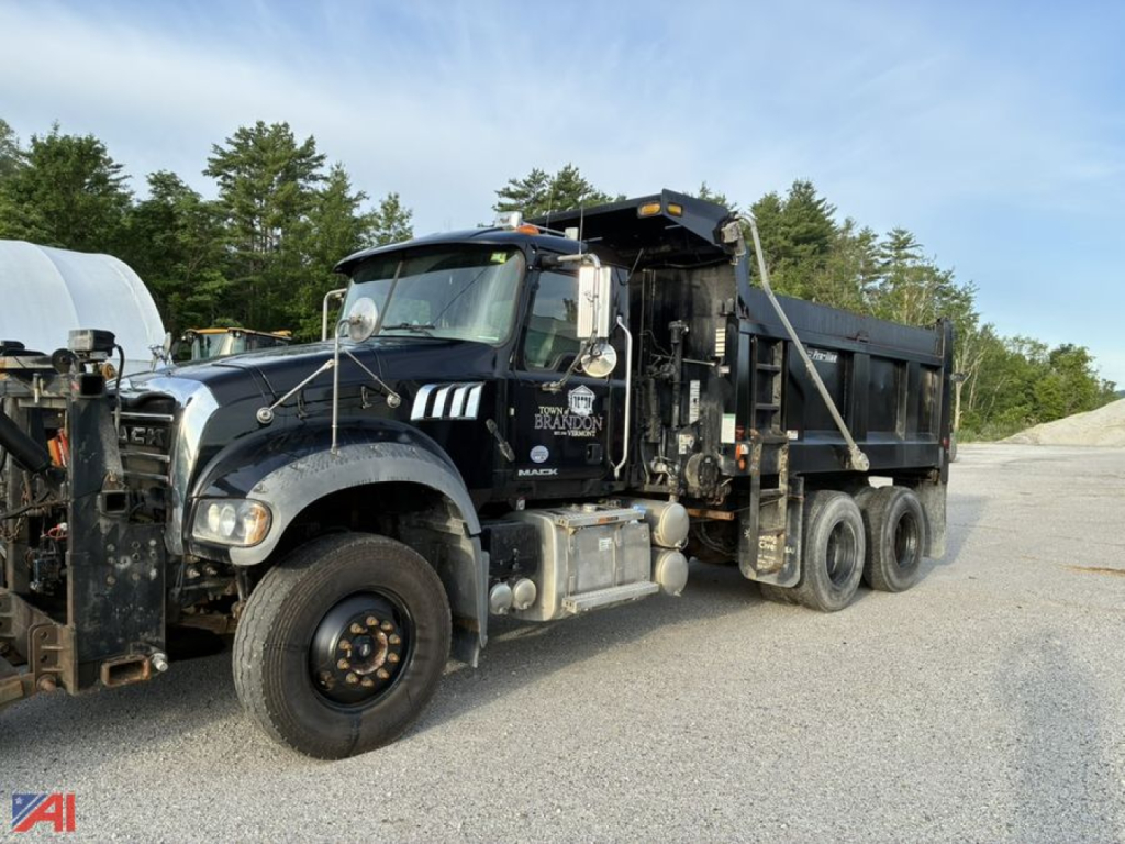2017 Mack Granite 64FR dump truck with plow in view showing front bumper, cab, dump bed, and plow hitch.