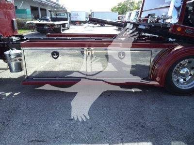 Rolback truck side storage box area showing chrome tool/storage compartments and maroon body with polished wheel.