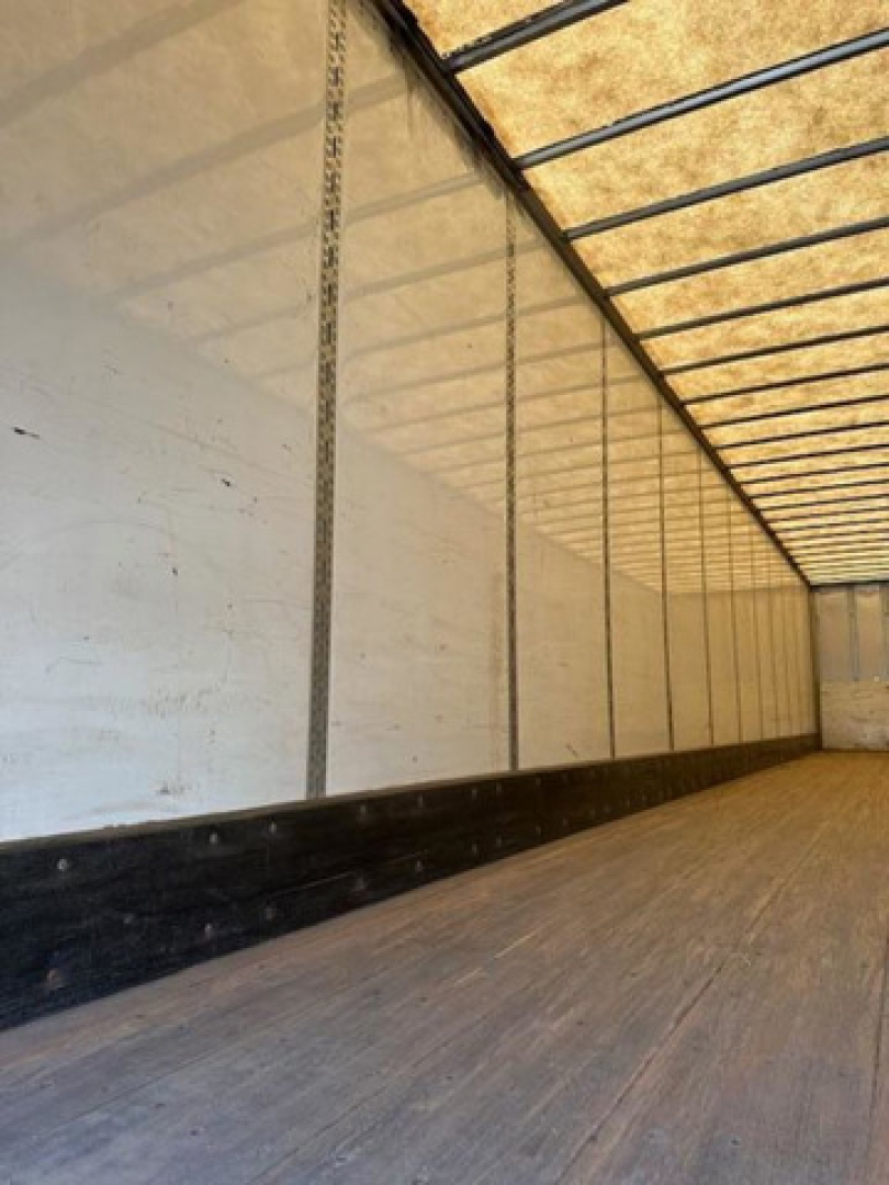Interior of a Wabash van trailer showing wooden floor and side walls with vertical support tracks.