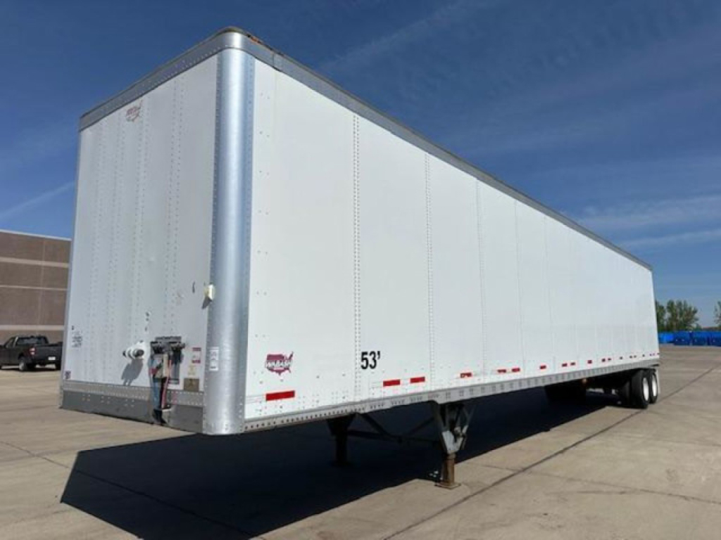 Trailer side view showing white Wabash van trailer with 53' length, raised landing gear, and rear doors; VIN 1JJV532D5GL908629 on listing tag.