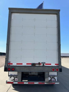 Rear view of a 2016 Wabash trailer showing a white closed box with rear doors, bumper, and reflector lights.