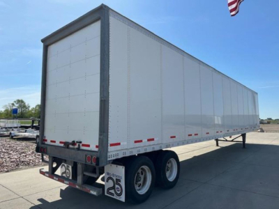 Trailer side view of a white 2016 Wabash van trailer showing dual rear axles and rear bumper with 25 mph sign.