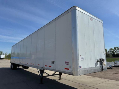 Trailer side view showing a white Wabash van trailer with front hitch and 53' length marking.