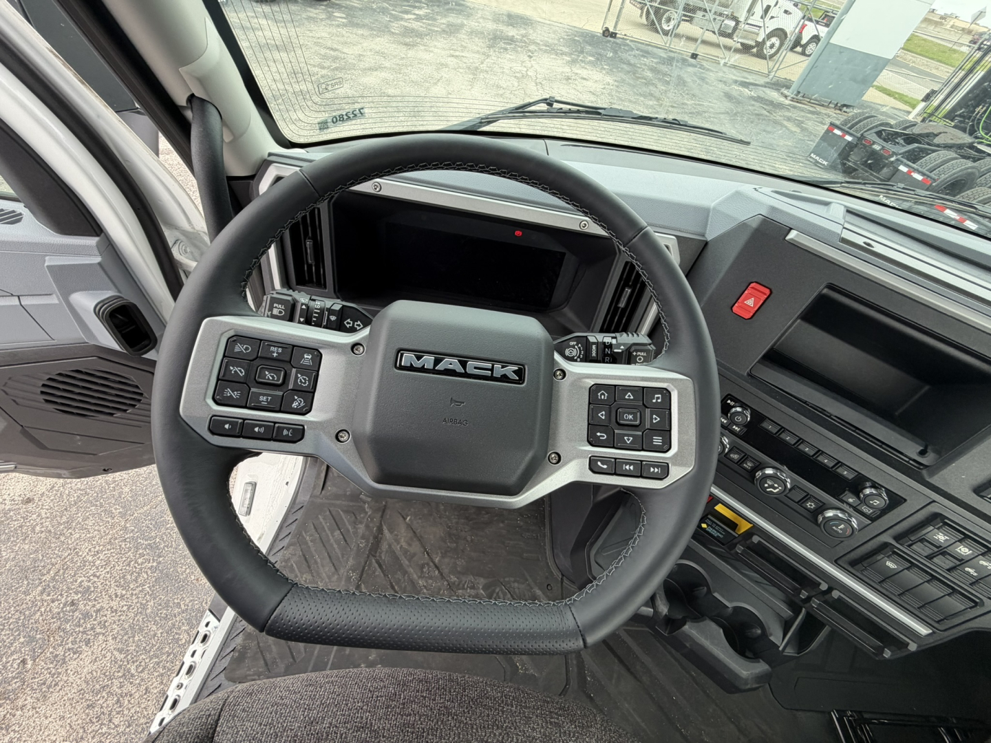 Mack AN64T truck cockpit showing steering wheel with Mack logo, dashboard, and center console controls.