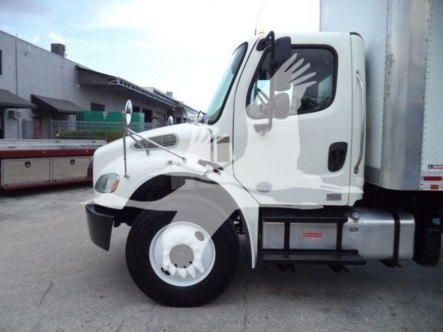 Freightliner M2 106 cab and front wheel area, white truck with side fuel tank, box truck body visible.