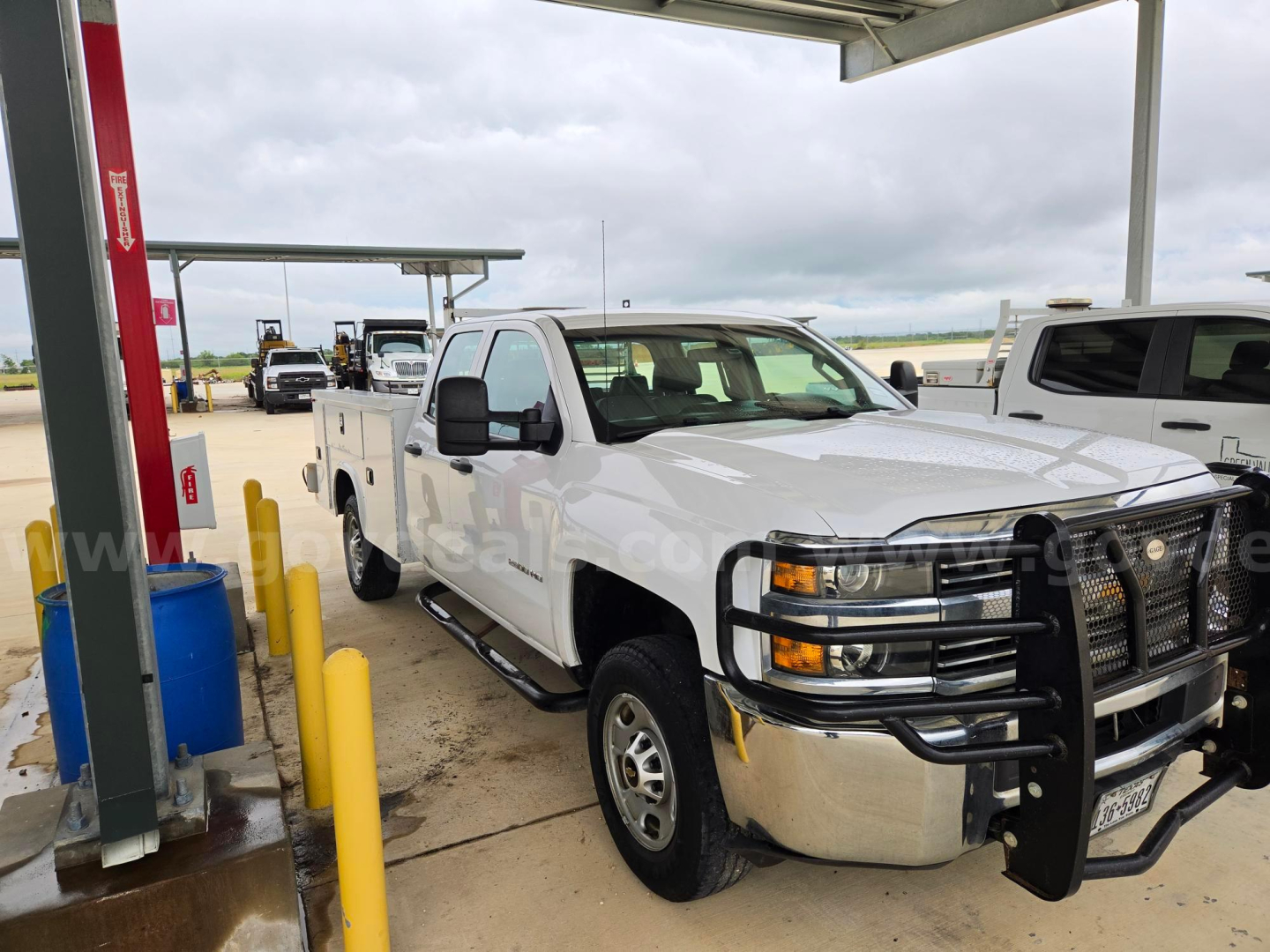 White 2017 Chevrolet Silverado 2500 pickup truck at a service lot with a large front bumper guard, dual rear wheels, and crew cab. visible text includes branding on truck and dealership watermark.