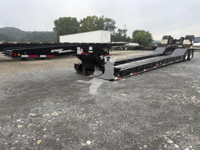 Trailer showing a lowboy form factor with a long black flatbed, dual rear axles, and ramp sections; visible labels include 'Eager Beaver' on the side.