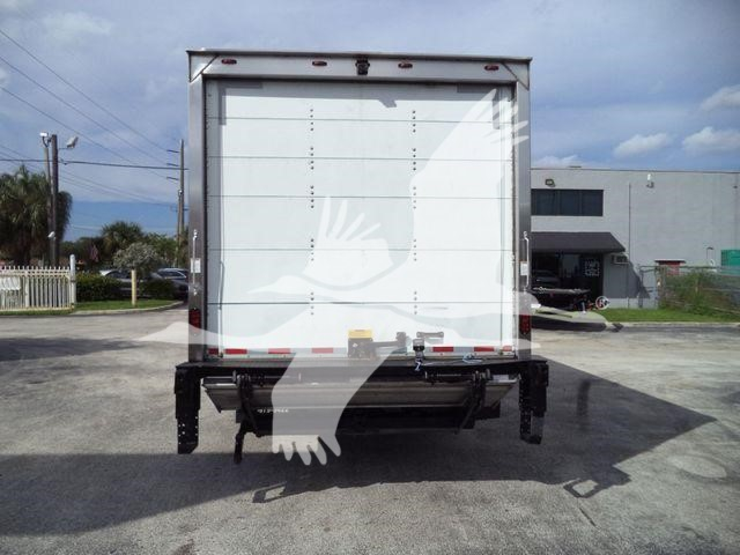 Isuzu NPR/NRR box truck rear view showing closed roll-up door and bumper.