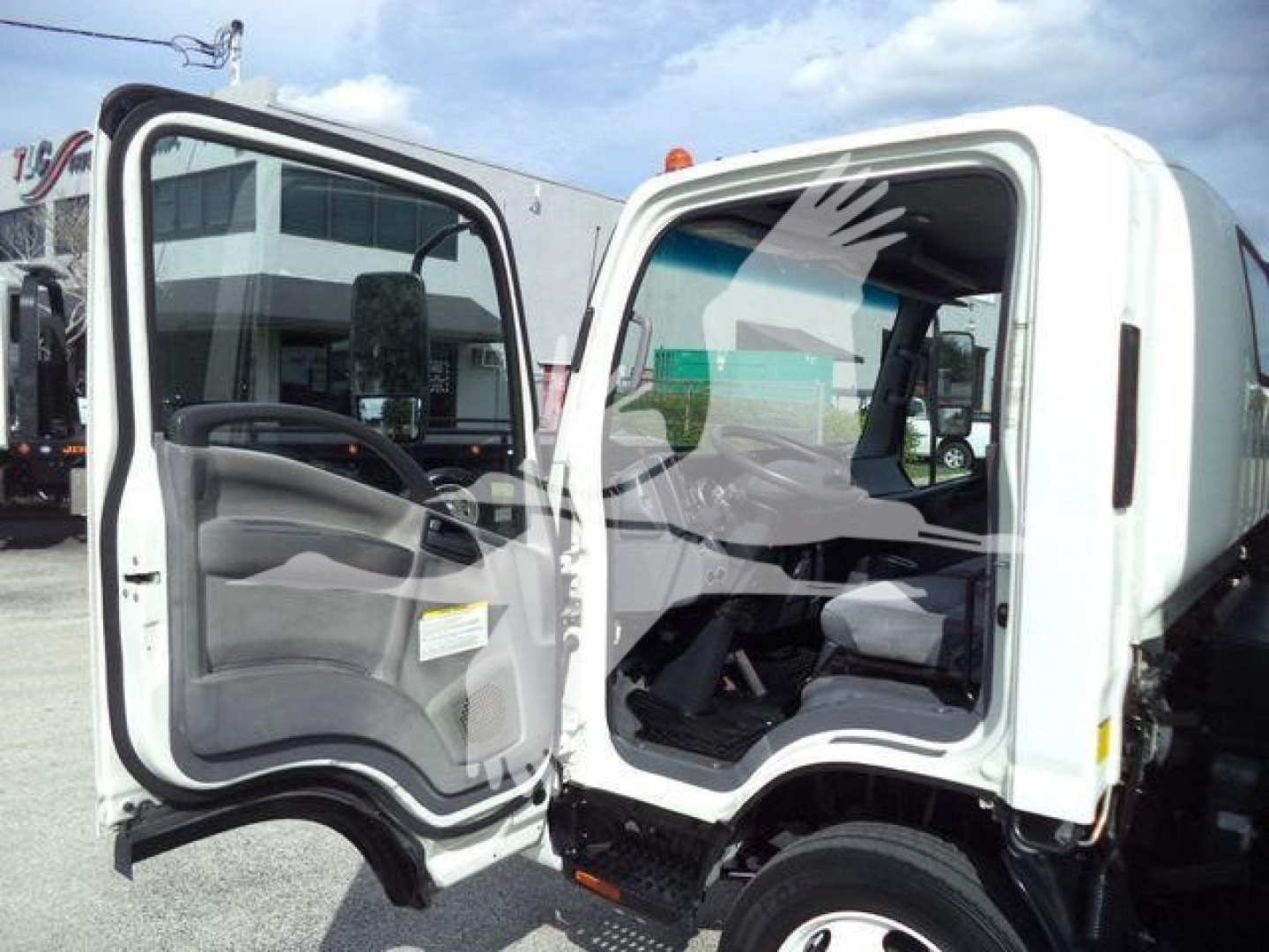 Isuzu NPR truck cab interior view with both doors open showing driver and passenger seats and dashboard