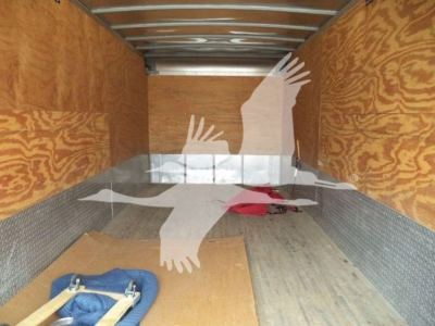 Truck cargo area showing wooden walls and metal lining with a few items on the floor; silhouette watermark obscures some of the space.