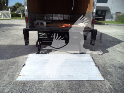 Isuzu NRR box truck rear with lowered aluminum ramp and open cargo area; rear loading area visible.