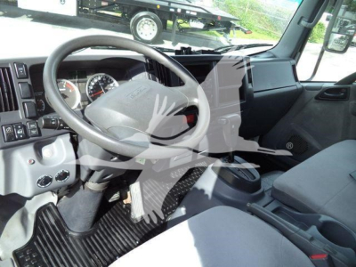 Isuzu NPRR cab interior showing steering wheel and dashboard view with center console and driver seat.