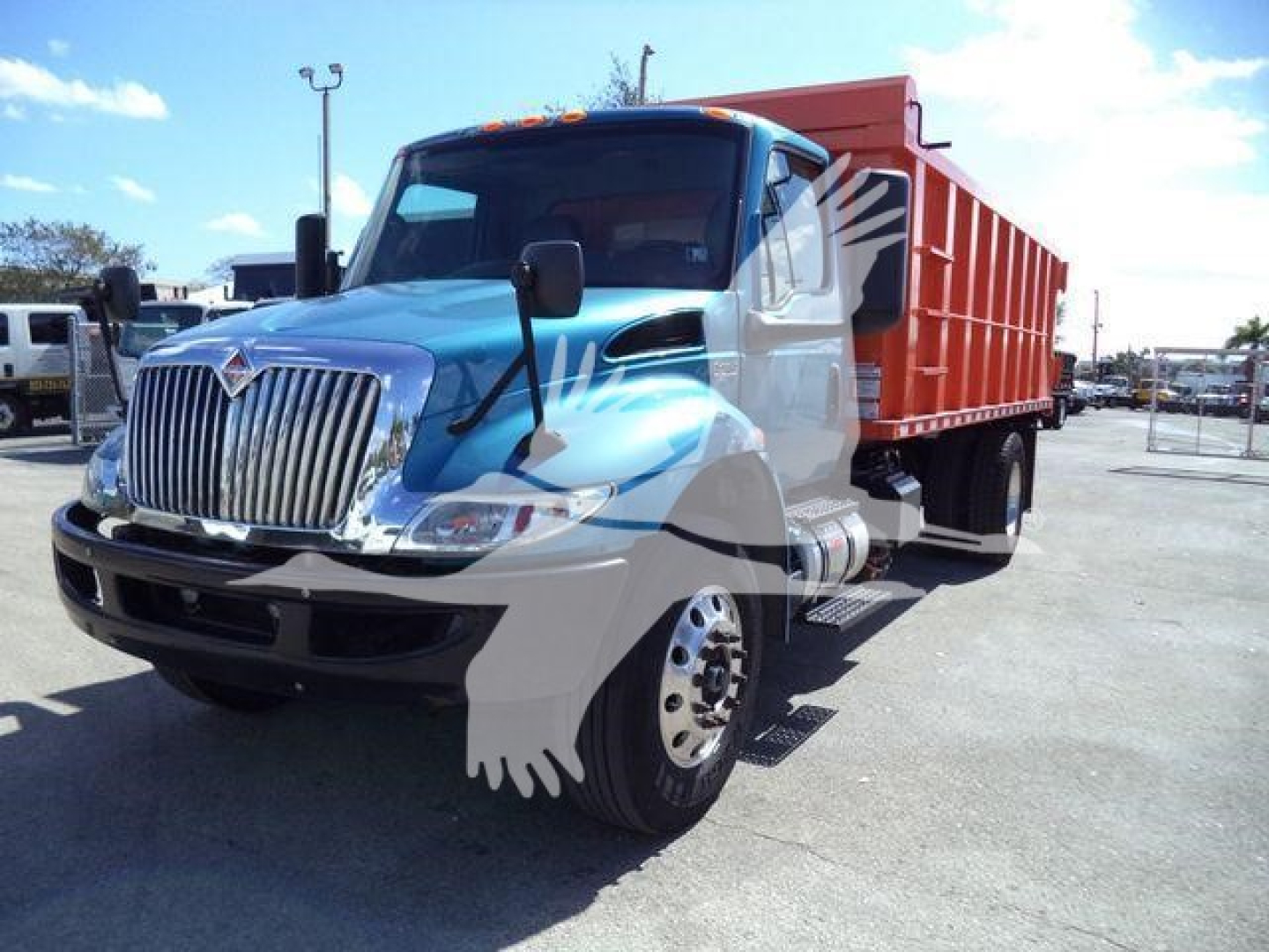 Dump truck 2020 International MV with blue cab and red dump body, side view showing front grille and wheel, stock #T51680.