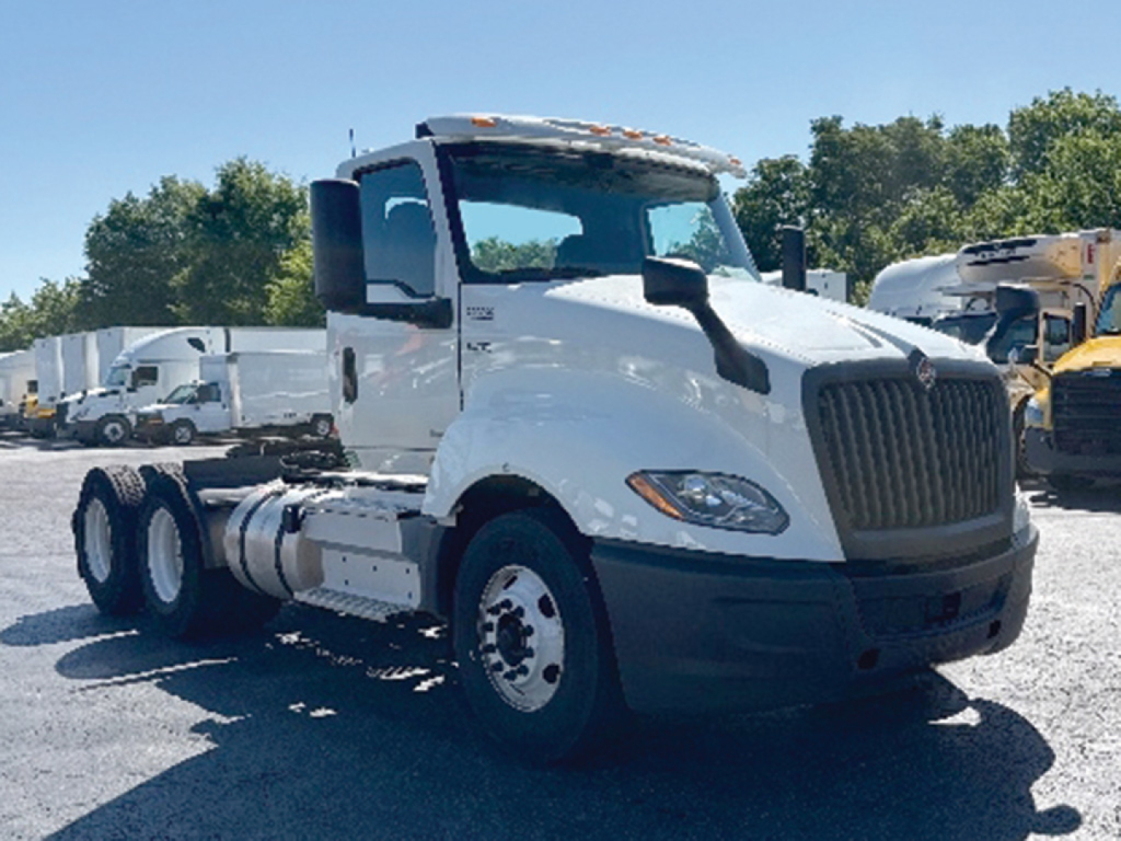 International LT625 daycab truck showing front and side view with white cab and black grille.