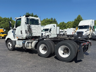 Truck chassis and cab in a parking lot showing International LT625 tractor with dual rear axles and fifth-wheel area.