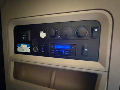 Kenworth T680 dash panel showing climate controls and radio unit, with various knobs and a small display.