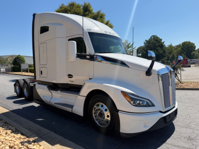 Kenworth T680 tractor in a yard, side view with sleeper cab and dual rear axles