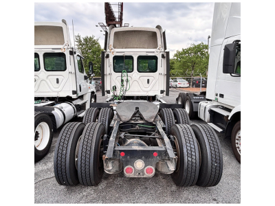 Truck rear view showing fifth wheel hitch and dual rear axles on a Freightliner Cascadia125 tractor with dual tires and mud flaps.