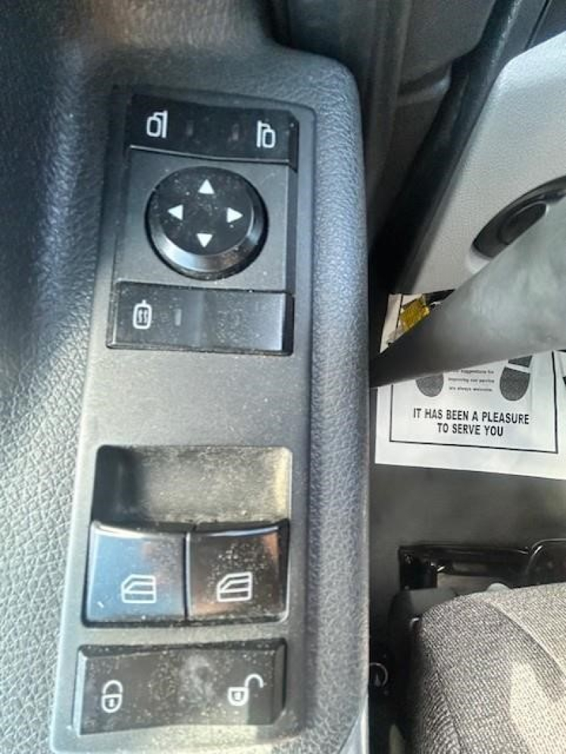 Dashboard window control panel view from a Freightliner Cascadia 126 showing mirror adjustment pad and window controls