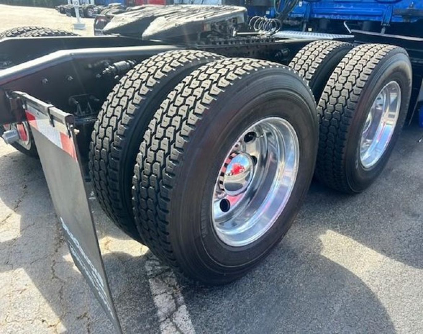 Freightliner Cascadia wheel pair on trailer chassis showing dual rear tires and polished chrome rims.
