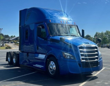 Freightliner Cascadia 126 left-side front view in blue, sleeper cab with chrome grille and dual rear axles.