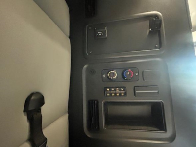 Cab interior of a 2022 Freightliner Cascadia 126 showing control panel with switches, knobs, and a small storage pocket.