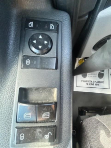Dashboard window control panel view from a Freightliner Cascadia 126 showing mirror adjustment pad and window controls