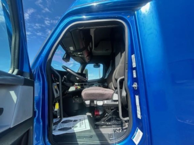 Freightliner Cascadia 126 truck cab interior view showing driver seat and dashboard.