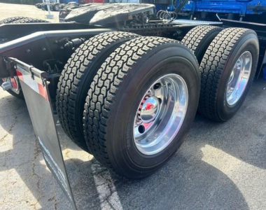 Freightliner Cascadia wheel pair on trailer chassis showing dual rear tires and polished chrome rims.