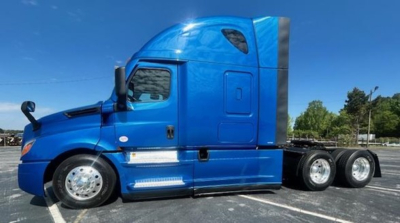 Freightliner Cascadia 126 sleeper cab side view showing blue exterior and triple rear axles.