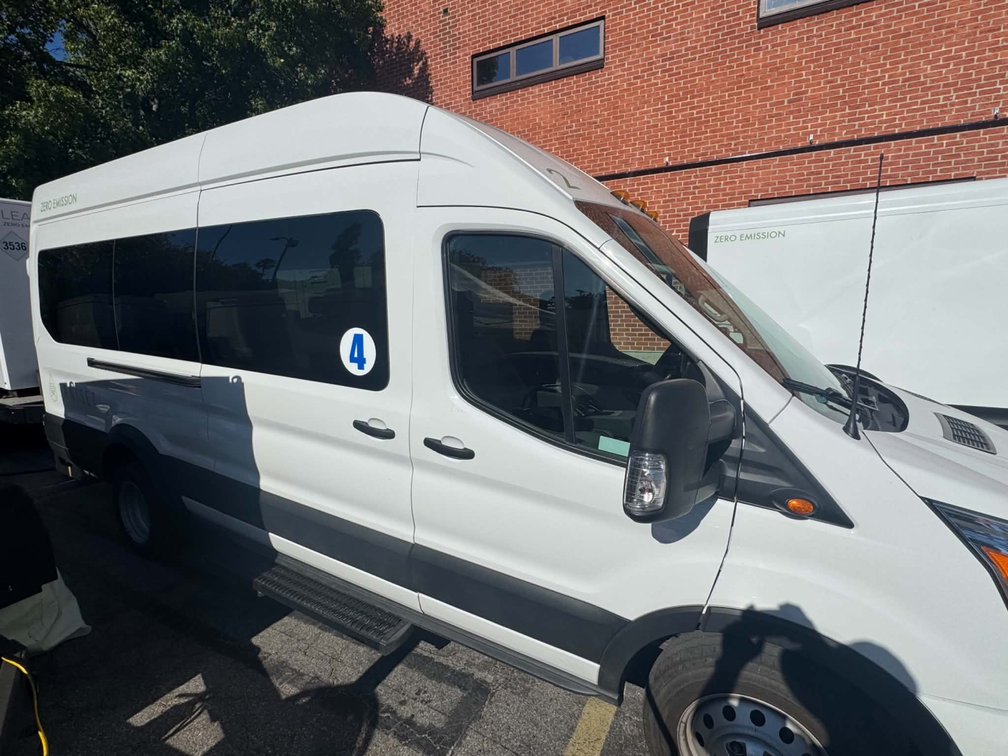 Ford Transit 350 HD XLT passenger van side view showing high roof, white exterior, black mirrors, side window, and VIN/branding not visible.