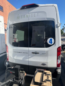 Ford Transit 350 HD cargo/passenger van rear view showing rear doors, bumper, and window with Saniset logo and a blue 4 sticker.