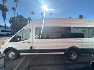 Ford Transit 350 HD XLT passenger van side view showing van with ‘ZERO EMISSI’ label and window sticker; VIN partially visible, external branding and wheel details.