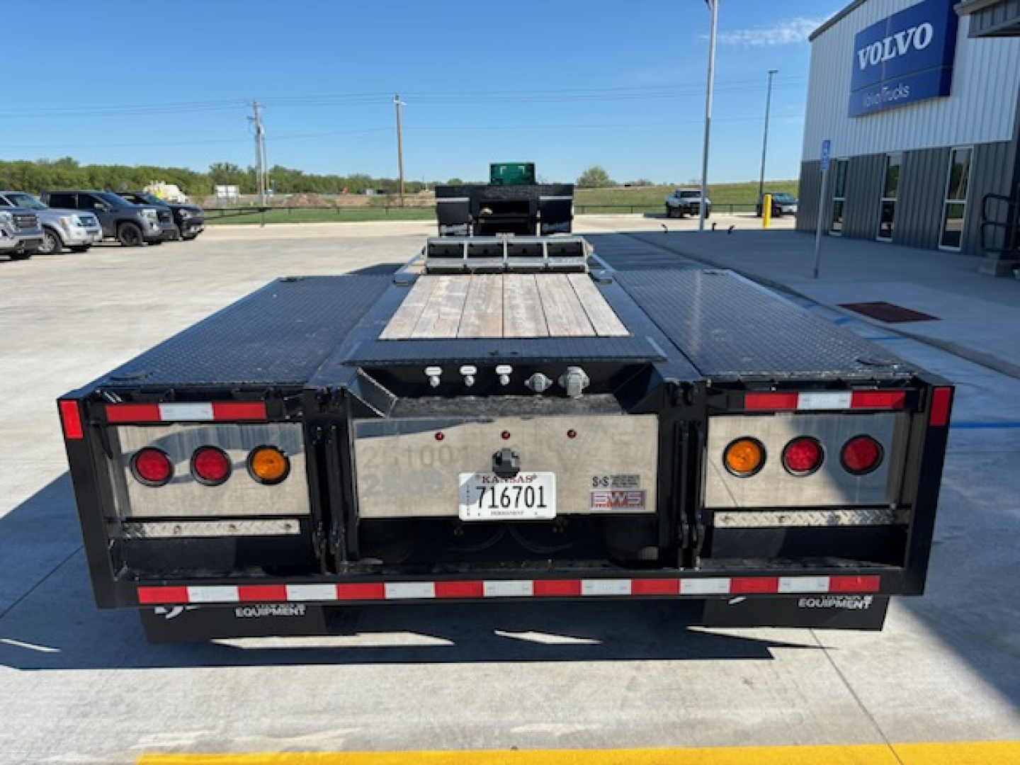 Trailer rear view showing flatbed equipment with lights and license plate area.