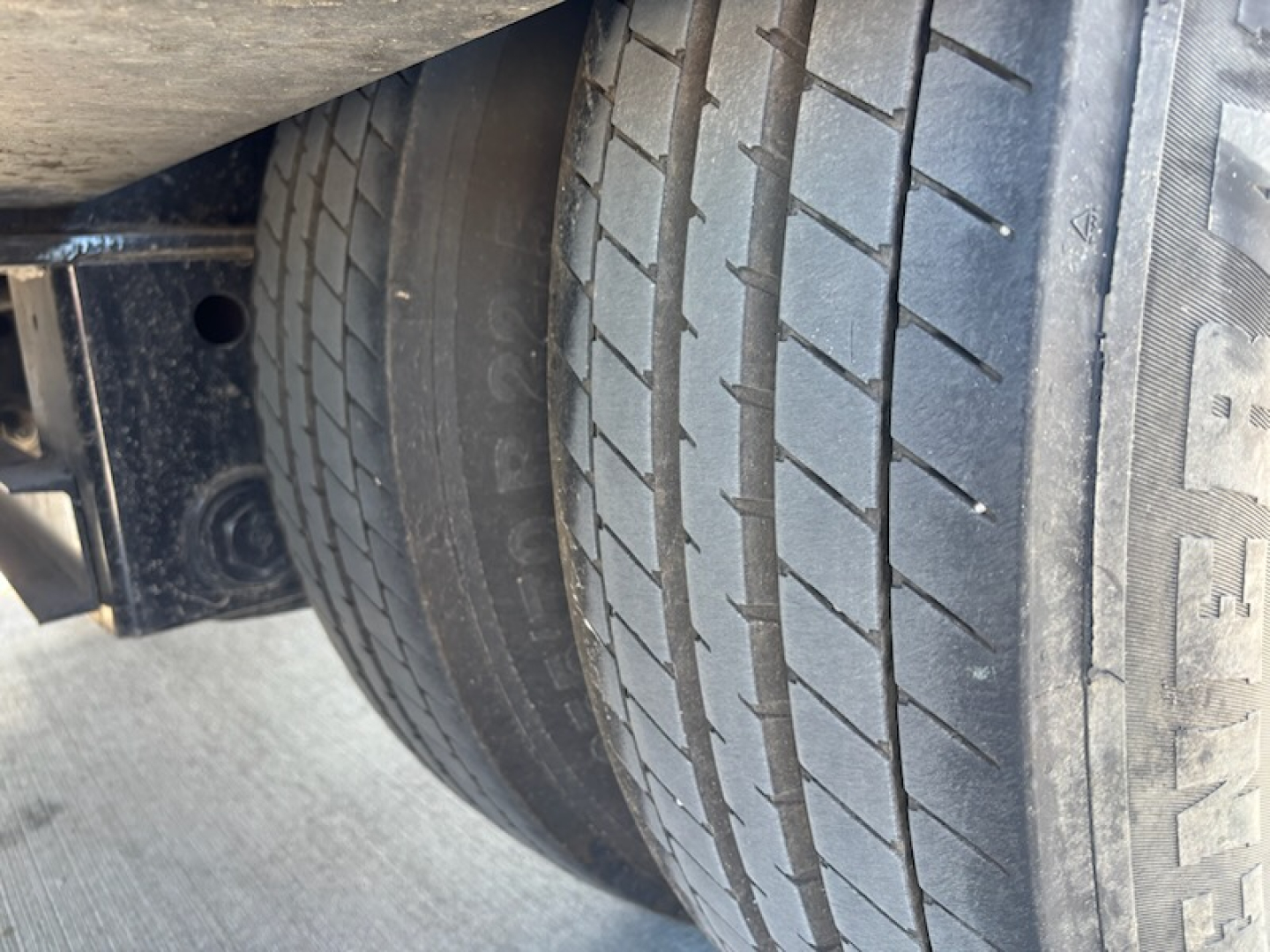Trailer wheel and tire view showing tire tread and sidewall markings.